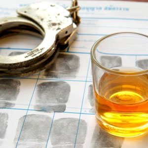 A glass of alcohol and handcuffs - The Law Office Of Michael D. Barber