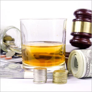 A glass of whiskey, money, and a gavel - The Law Office Of Michael D. Barber.