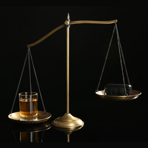 A scale with a glass of wine and a razor, symbolizing DUI penalties in Florida - The Law Office Of Michael D. Barber